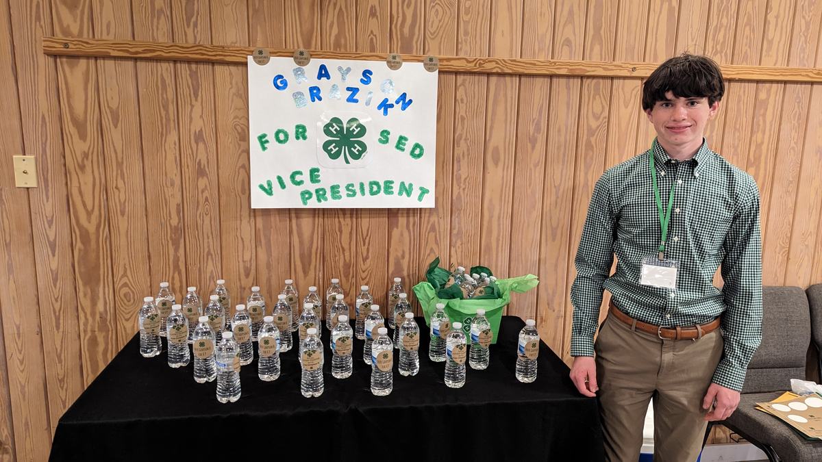 White male teen in green shirt campaigns for district office
