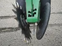 Fluted planter disc opener and adjacent rubber gauge wheel on green implement