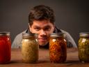 man looking at jars of fermented products