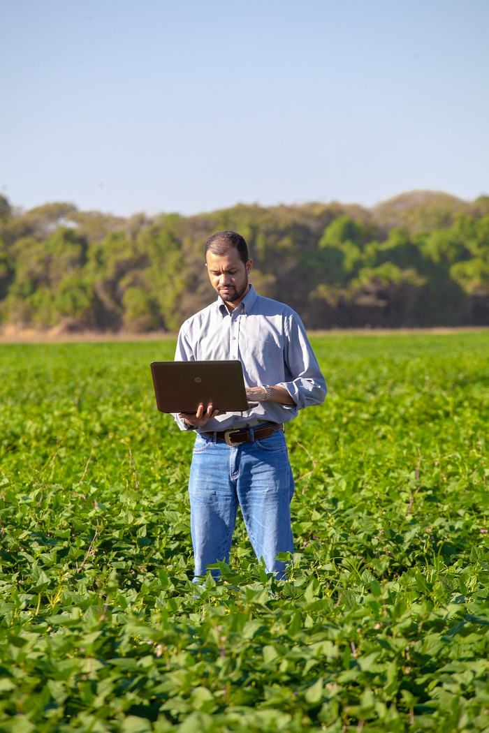 Man Holding computer in a field.