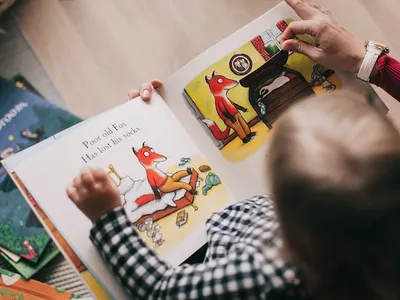 adult reading a book to a small child