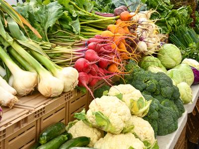 Radishes, golden beets, garlic, cauliflower, broccoli and cabbages displayed at a market stall