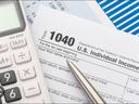 Form 1040 U.S. Individual Income Tax with pen and calculator