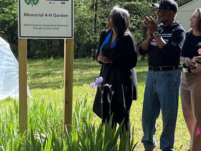 Tarleton & Bonnie Davis Memorial 4-H Garden sign with people standing beside it