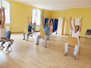 Women doing yoga in chairs.