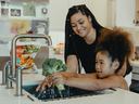 Mom and daughter washing broccoli in sink