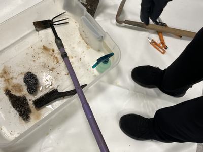 plastic tub with rusty garden hoe in vinegar