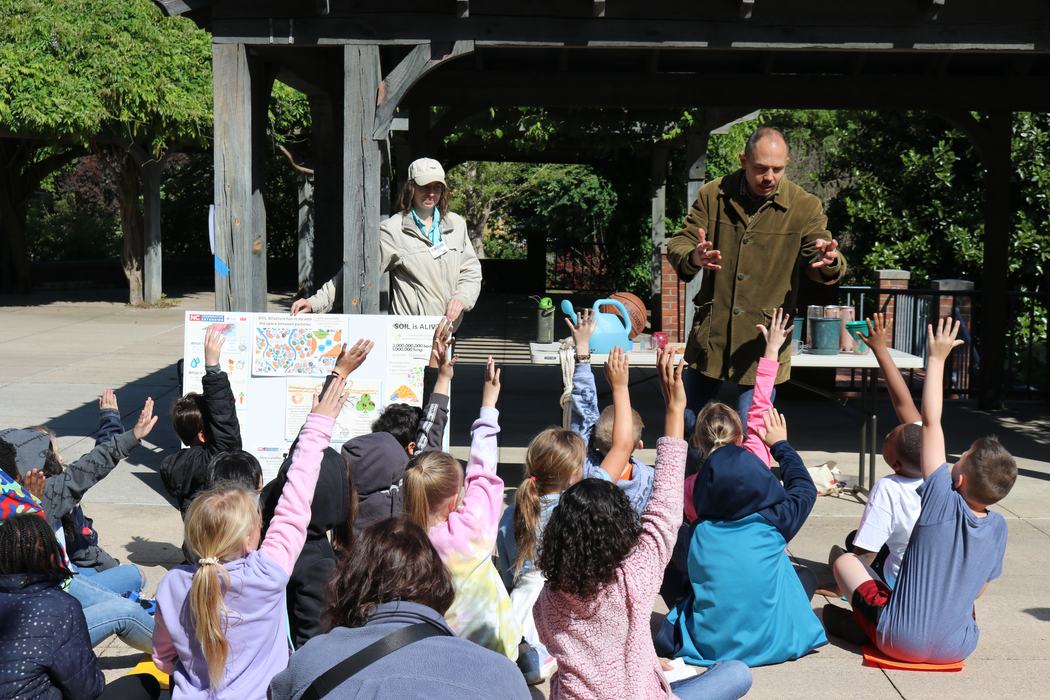 Two adults teaching kids a lesson about soil