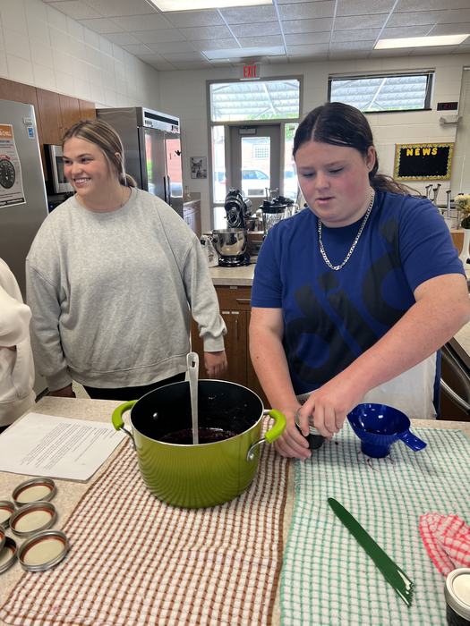 A teenager closes a jar of preserves.