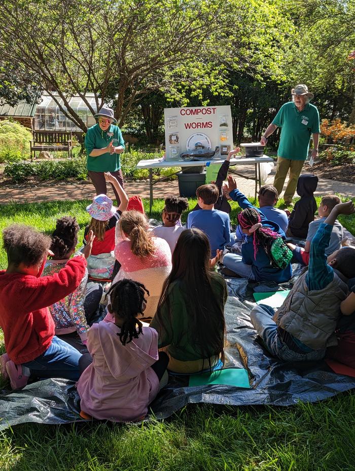 Adults teaching kids about composting