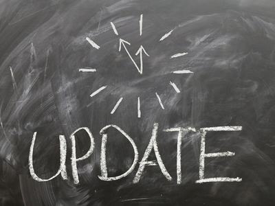 Blackboard surface with a clock face and the word update written in white chalk