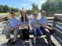 A group at a pond poses on a dock.
