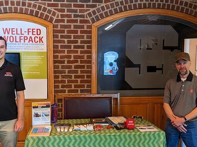 Alex Chouljenko and Greg Bolton standing at a booth providing information about seafood safety.