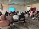Photo of 20 seafood processing workers attend video training class.