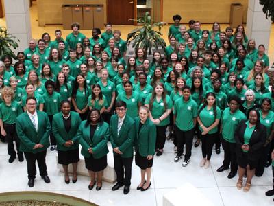 Photo of all CNCF delegates in green shirts and black pants or skirts