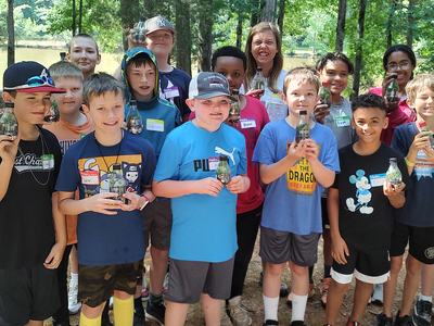 A group of kids hold bottles to the camera.