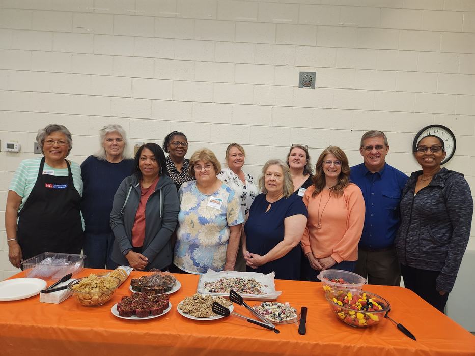A group stands behind a table with healthy snacks.
