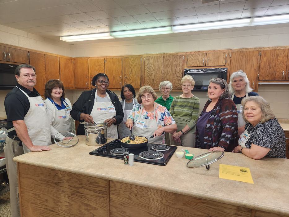 A class works in a kitchen to prepare a meal.