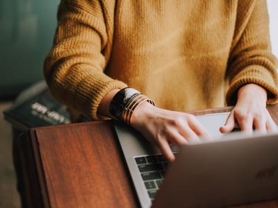 Aerial view of a woman typing on a laptop.
