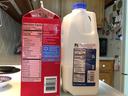 Red soy milk carton (Calories 100) beside 2% milk jug (Calories 120) on kitchen counter