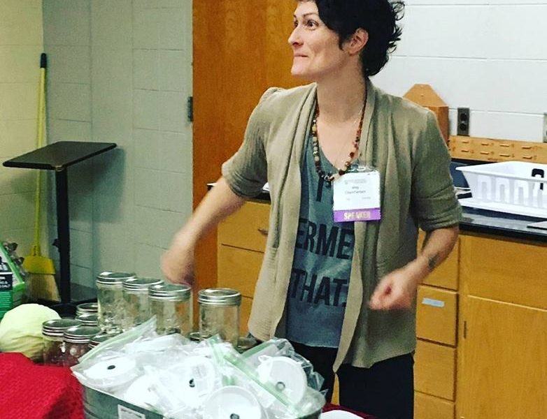 A woman shows off fermenting equipment.