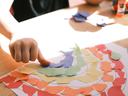 girl creating rainbow with colored paper