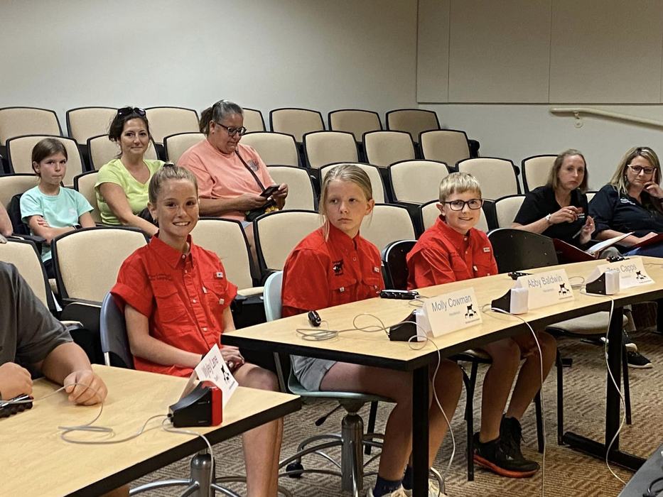 Children at quiz bowl tables.