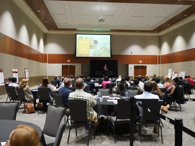 People sit in a conference room listening to a speaker