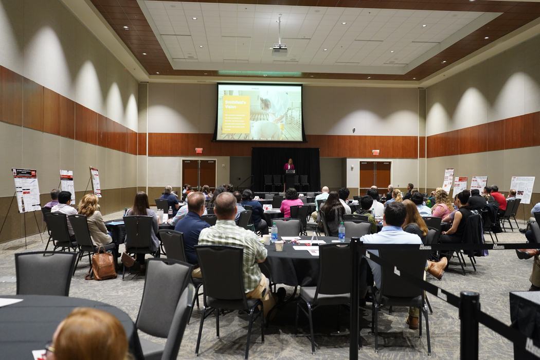 People sit in a conference room listening to a speaker