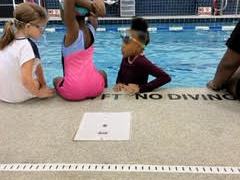 Children on the side of a pool.
