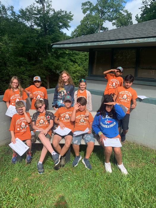 Group of kids sit together at summer camp