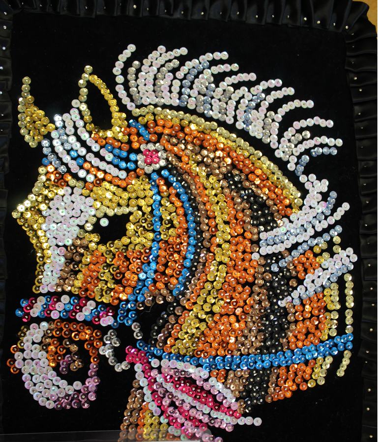 Sequin mosaic of a horse head with a horn on black fabric background