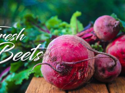 Three red beets with greens on a wooden surface; overlaid text "Fresh Beets"