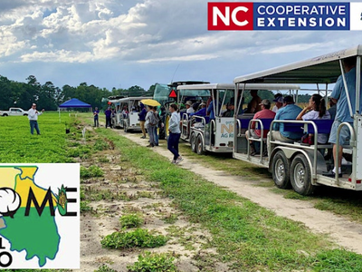 Tram of people touring a crop research field with a presenter; text "NC Cooperative Extension" and "Regional Ag Expo"
