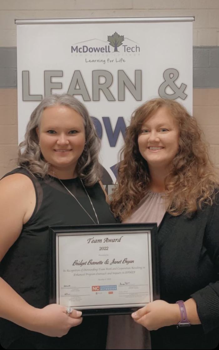 Two women pose with a certificate.