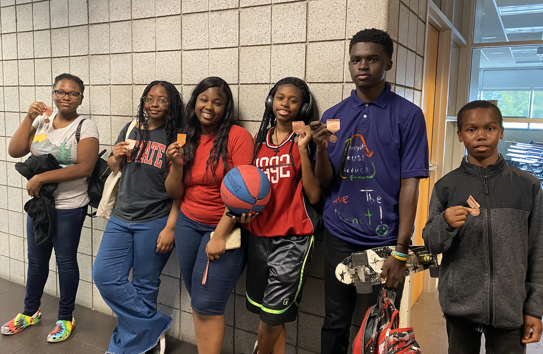 A group of children hold medals.