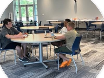 Kids sit around a table having a snack.
