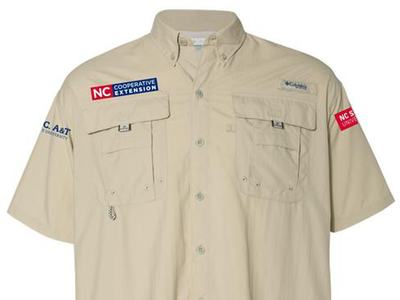 Beige short-sleeve button shirt with patches reading "NC Cooperative Extension" and "NC State"