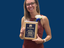 Olivia Patchel holding Distinguished Service Award