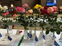 Award-winning roses in vases with ribbons displayed on a table