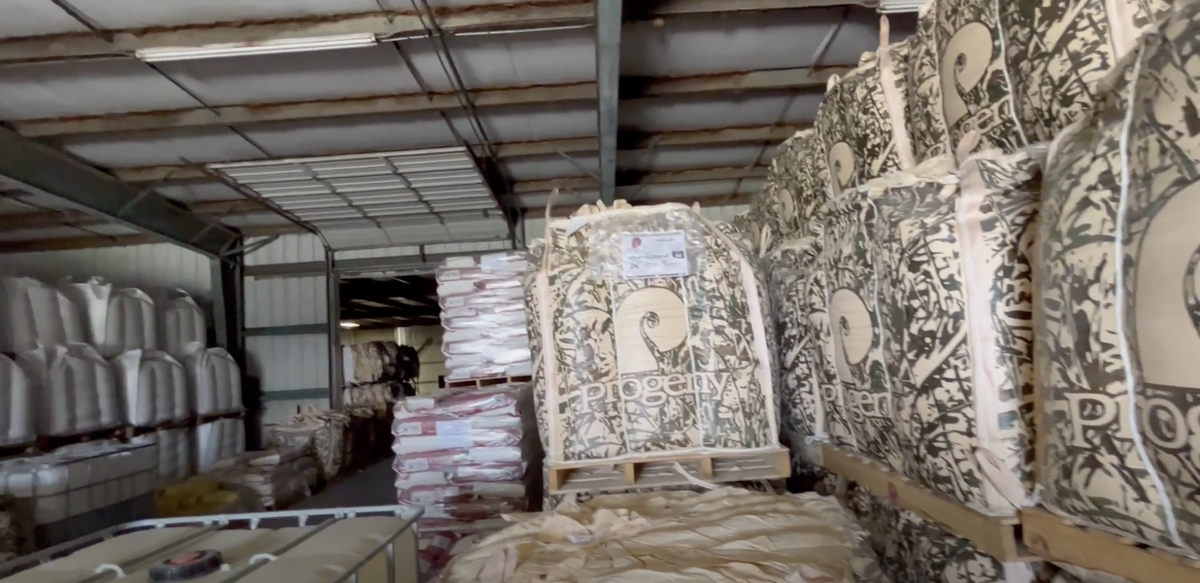 Stacked large printed bulk bags labeled "Plogger" inside a warehouse