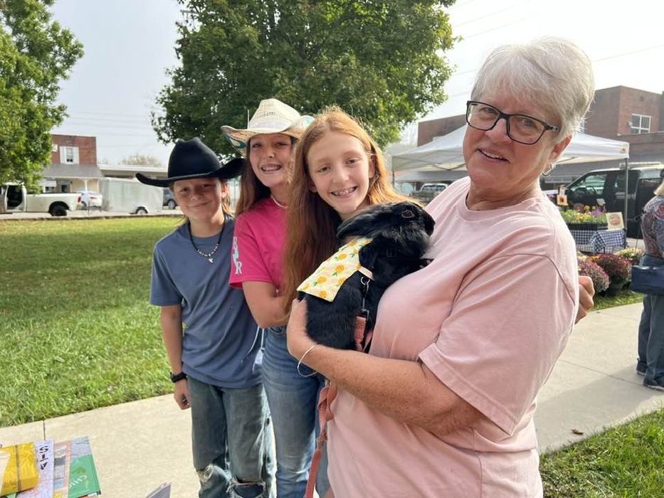 4 people and woman with pink t-shirt holding a rabbit in a harness