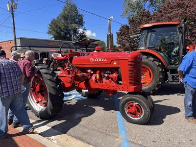Men look at red tractor