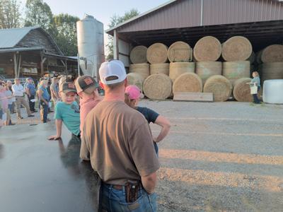 people looking at hay in a barn