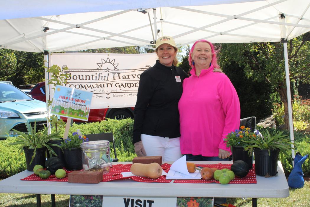 Two women pose at a table for the Bountiful harvest Community Garden