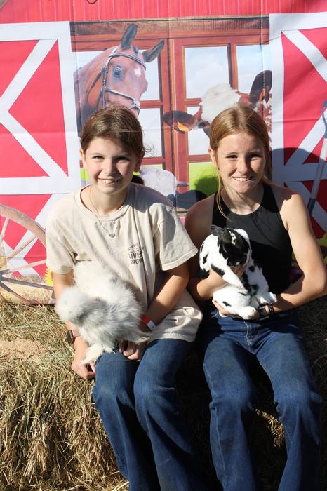 Two children pose with rabbits.