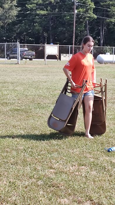 Sarah Beth Cleaning up chairs from a field after an event