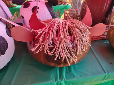Pumpkin decorated with yarn fringe, paper horns and ears resembling a shaggy cow