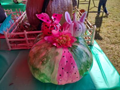 Large pumpkin painted like a watermelon with a bunny mini-pumpkin and ladybug mini-pumpkin