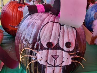 Painted pumpkin decorated as a rabbit: button eyes, paper ears, and straw whiskers